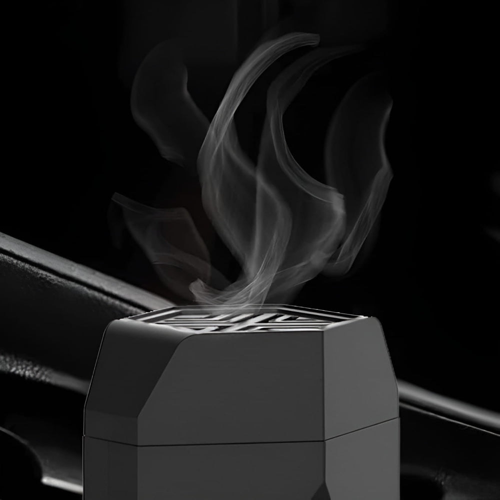 Close-up of smoke releasing from the top vent of a black electric hair bakhoor comb burner.