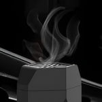 Close-up of smoke releasing from the top vent of a black electric hair bakhoor comb burner.