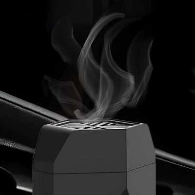 Close-up of smoke releasing from the top vent of a black electric hair bakhoor comb burner.